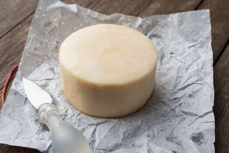 Brazilian Mantiqueira artisanal cheese over a wooden table.