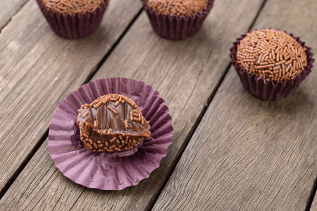 Typical brazilian brigadeiros, various flavors over wooden table.の写真素材