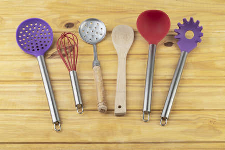 Colorful kitchen utensils over wooden table.