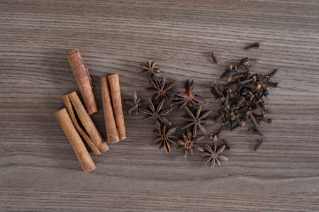 Cinnamon sticks, star anise and cloves over wooden table