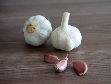 Garlic bulbs and cloves over wood backgroundの写真素材