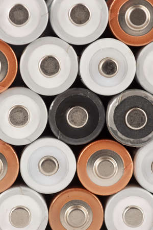 Pile of old white, black and golden AA batteries showing positive endの写真素材