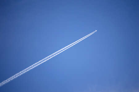 Airplane and jet stream with clear blue skies backgound