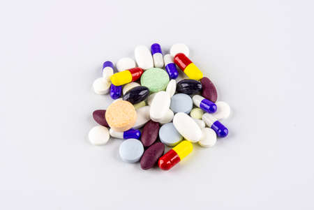 Group of pills, capsules and other coloful medications over white background