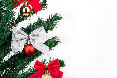 Christmas balls and bows in a tree over white background with copy space.