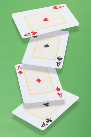 Four aces cards floating over green background.
