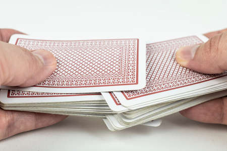 Hands shuffling playing cards on white background.の写真素材