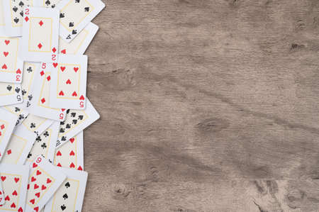Playing cards over wooden background with copy space.