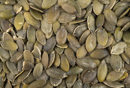 Top closeup view of squash seeds. Food backdrop.
