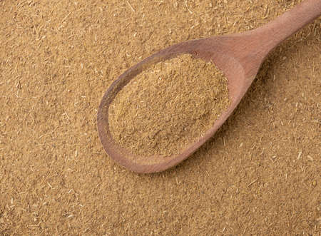 Top view, closeup of ground cumin on a wooden spoon.の写真素材