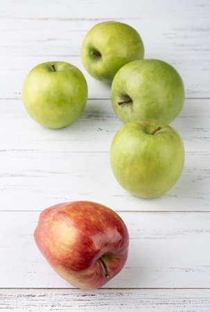 Green and red apples over white wooden table.の写真素材
