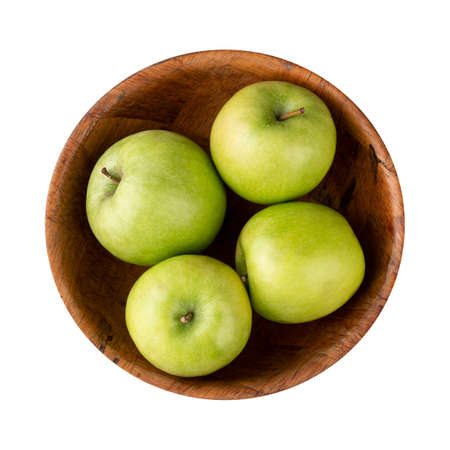 Green apples in a bowl isolated over white background.の写真素材