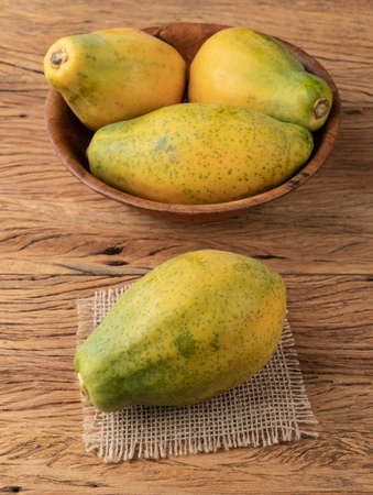 Papayas in a bowl over wooden table.の写真素材