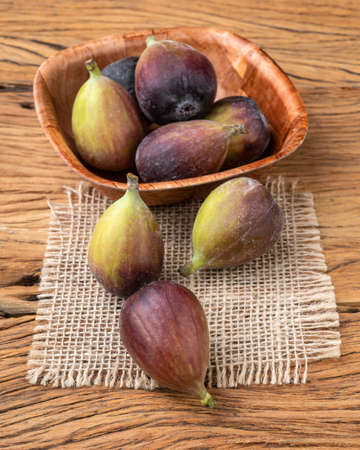 Figs in a bowl over wooden table. Short depth of field.