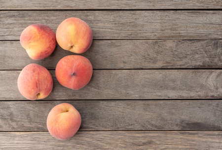A group of peaches over wooden table with copy space.の写真素材