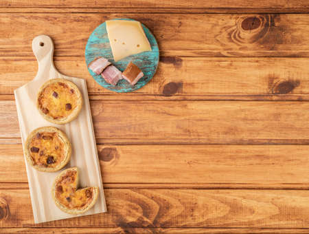 Homemade quiche lorraine over wooden board with ingredients and copy space.の写真素材