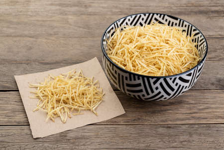 Potato straw or shoestring potato in a bowl over wooden table.の写真素材