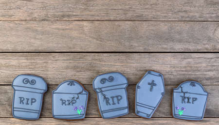Halloween gingerbreads, tombstone shaped over wooden table with copy space.の写真素材