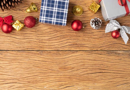Gift boxes, christmas balls, bell, pinecone and bow over wooden table. Christmas decoration with...