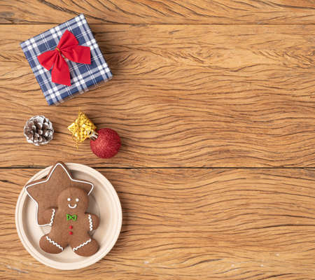 Traditional christmas gingerbread cookies over a wooden table with gift box and christmas...