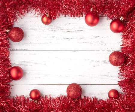 Frame with christmas balls, gift boxes and bells over wooden table with copy space.の写真素材