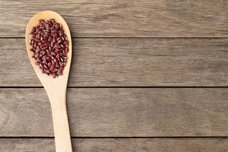 Azuki beans in a spoon over wooden table with copy space.の写真素材