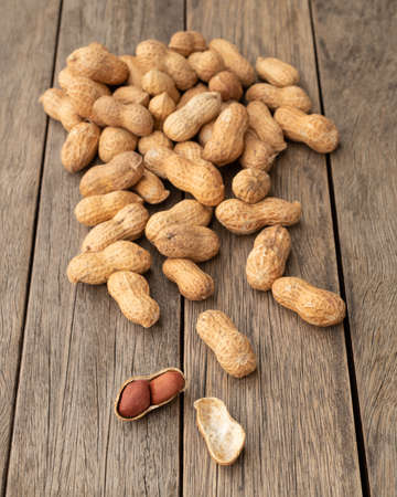 A pile of shelled peanuts over wooden table.の写真素材