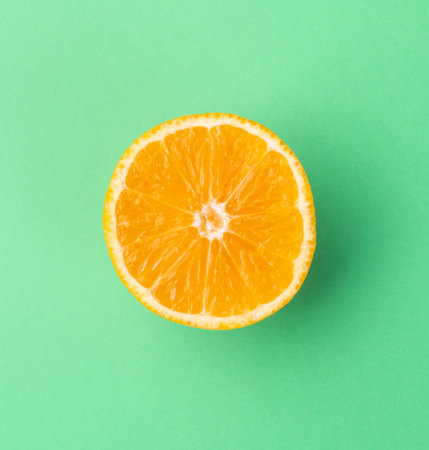 Orange half isolated over green textured background.