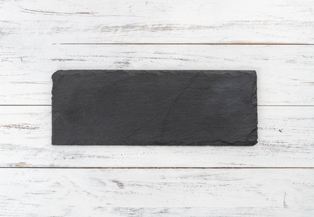 Empty stone board with copy space over wooden table.