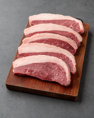 Sliced raw picanha or rump meat over wooden board.の写真素材