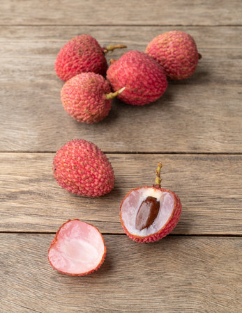 Lychees cut fruit over wooden table.
