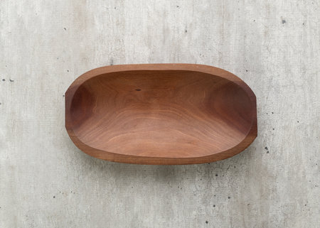 Empty handmade wooden bowl over wooden table.