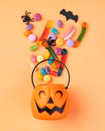 Assorted colorful candies over orange background..