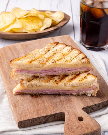Cheese and ham sandwich with potato chips and soda.の写真素材