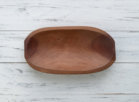 Empty handmade wooden bowl over white wooden table.の写真素材