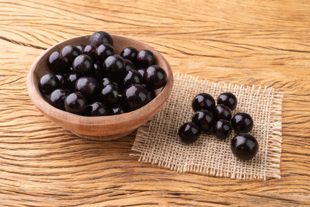 Jabuticabas on a bowl over wooden table.の写真素材