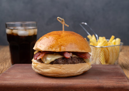 Cheeseburger with bacon on wooden board with french fries and soda.の写真素材
