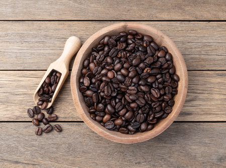 Coffee beans in a bowl over wooden table.の写真素材