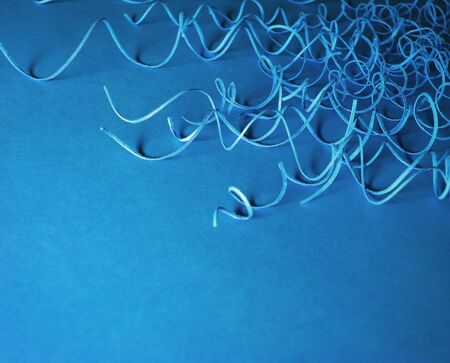 Blue background with paper curlsの写真素材