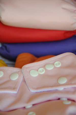 Pink cloth diaper in focus with different colored diapers at the backgroundの写真素材