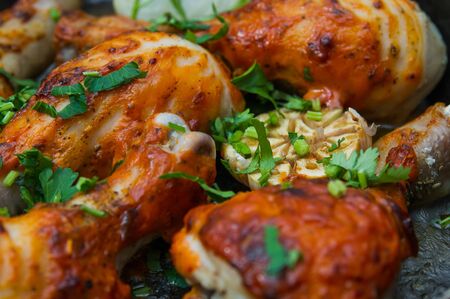 fried chicken drumsticks in a frying pan on wooden tableの写真素材