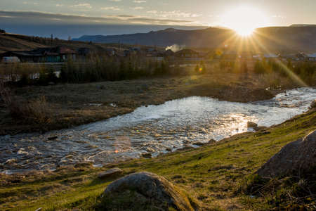 A rough mountain river flows next to the villageの写真素材