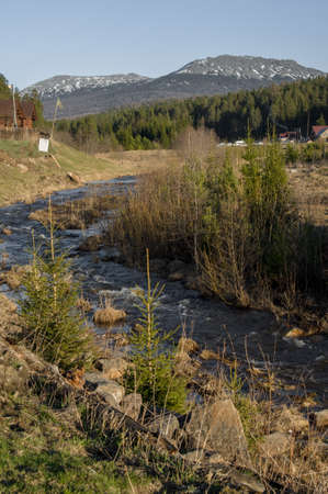 A rough mountain river flows next to the villageの写真素材