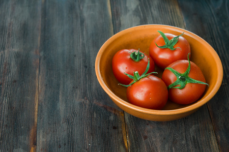 Juicy ripe red tomatoes on a wooden tableの写真素材