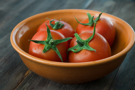 Juicy ripe red tomatoes on a wooden tableの写真素材