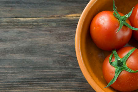 Juicy ripe red tomatoes on a wooden tableの写真素材