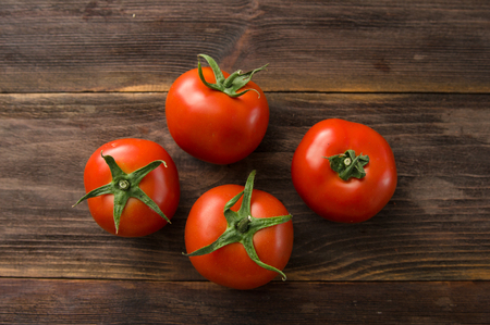 Juicy ripe red tomatoes on a wooden tableの写真素材