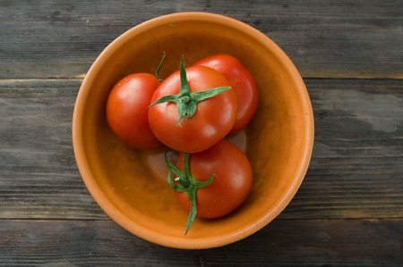 Juicy ripe red tomatoes on a wooden tableの写真素材