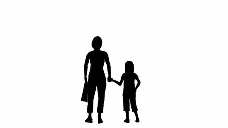 silhouette of an adult woman carrying a bag holding a small childの写真素材