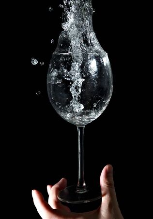 The stream of water pours into the glass の写真素材